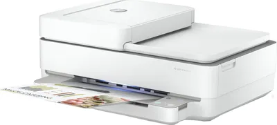 A white HP Envy 6420 printer is shown from a slightly elevated side angle, with a document partially printed and emerging from the front output tray.