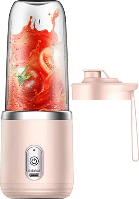 A pink portable blender with a clear cup filled with tomatoes and juice, shown with its pink lid.