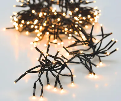 A close-up shot of a string of warm white LED lights on a white background.