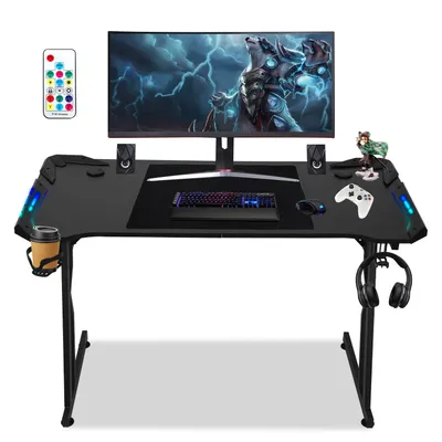 A gaming desk setup with a monitor, keyboard, mouse, and accessories.