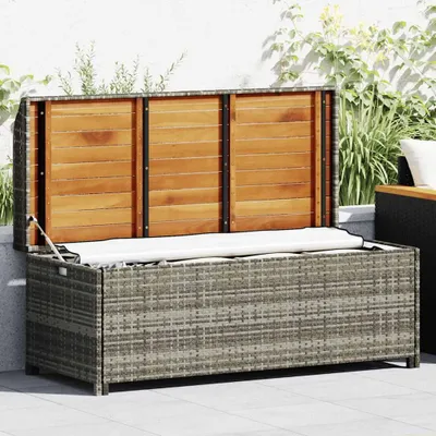 An open storage bench with a wooden lid, placed on a patio.