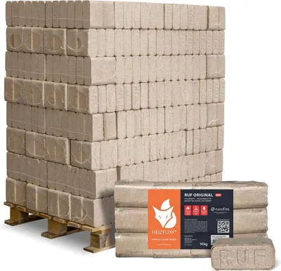 A pallet stacked with firewood briquettes, with a package of briquettes in the foreground.