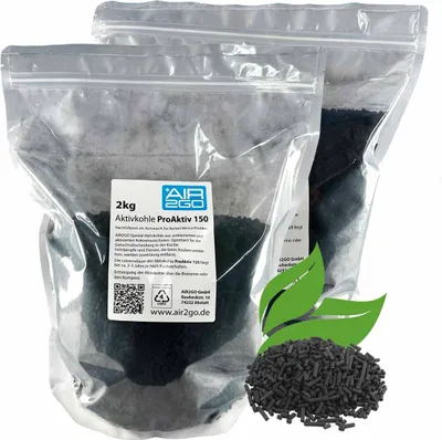 Two sealed plastic bags of activated charcoal pellets, with a label on one bag, and a pile of pellets with green leaves in the foreground.