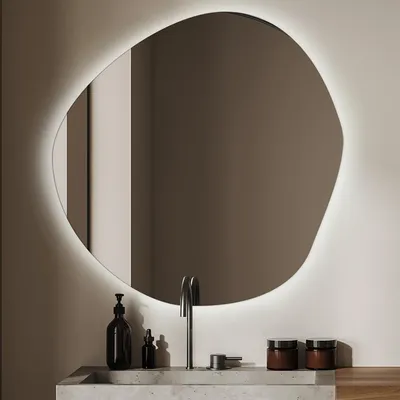 A modern bathroom vanity with a sink, faucet, and an illuminated, irregularly shaped mirror.