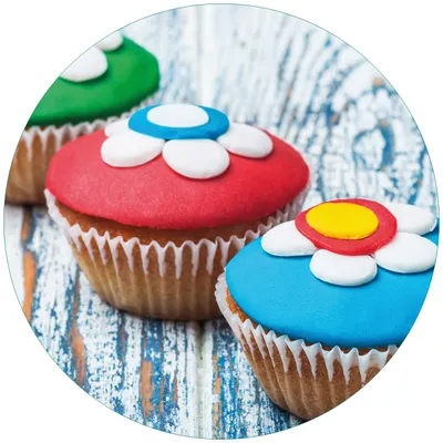 Produktbild von Wallario Premium Glasbild, freischwebende Optik, kräftige Farben, rund 50cm Durchmesser, Motiv Bunte Muffins - alter Holztisch - Stillleben
