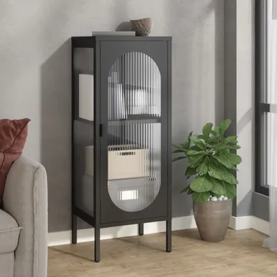 A dark gray metal cabinet with fluted glass doors is shown in a room setting next to a sofa and a potted plant.