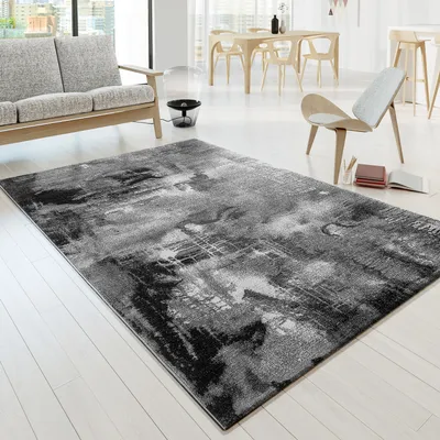 A modern living room with a sofa, rug, and dining set.