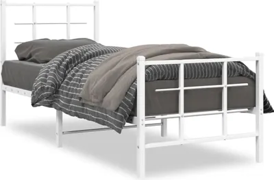A white metal bed frame with bedding.