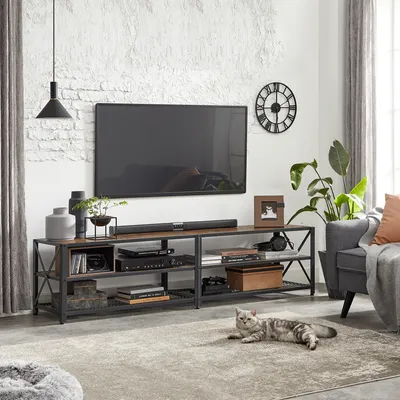 A living room scene featuring a TV stand with a television, soundbar, and decorative items, with a cat lying on the rug in the foreground.