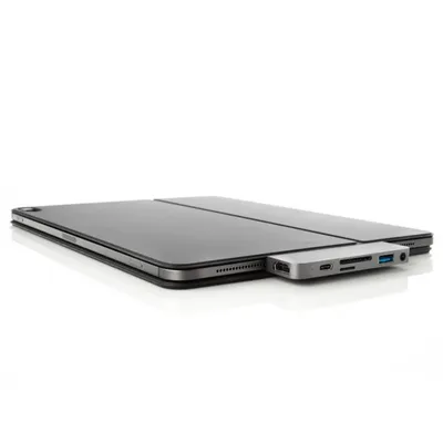 A silver USB-C hub is connected to a gray tablet case, shown on a white background.