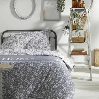 A bedroom scene with a bed, pillows, and a decorative ladder shelf.