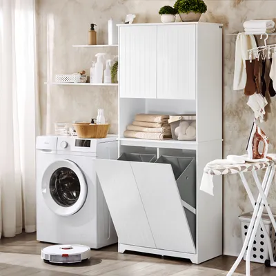 A laundry room scene with a washing machine, a tall white cabinet with storage and laundry baskets, and an ironing board.