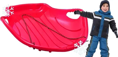 A child in winter clothing is holding a red plastic sled.
