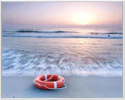 Produktbild von Wallario Wandbild Rettungsring am Strand bei Sonnenuntergang, Größe: 40,30 x 50,30 cm, Poster mit weißem Aluminiumrahmen