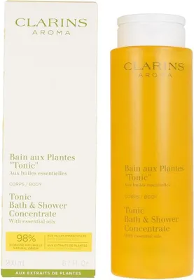 A product shot of a Clarins bath and shower concentrate bottle and its packaging.