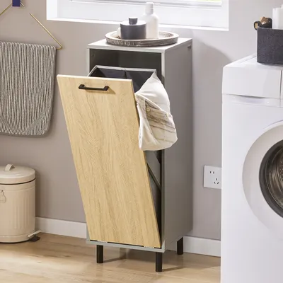 A laundry room scene with a washing machine, laundry hamper, and trash can.