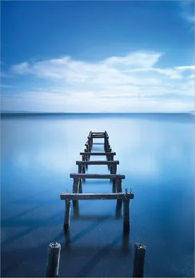 Produktbild von Wallario Poster - Rustikaler Holzsteg im blauen See, Kunstdruck Größe: 70 x 100 cm