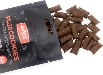 A bag of dog treats with some treats spilled out.