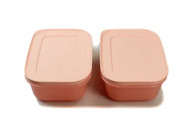 Two pink food storage containers with lids are shown side-by-side on a white background.