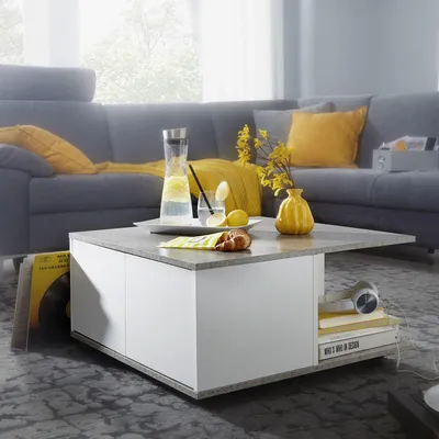 A living room scene with a coffee table in the foreground and a sofa in the background.