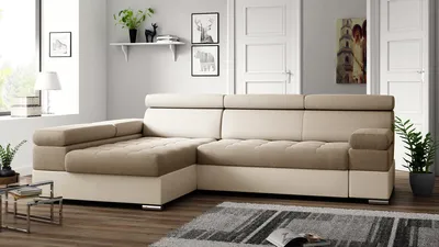 A modern living room with a sectional sofa, rug, and decorative items.