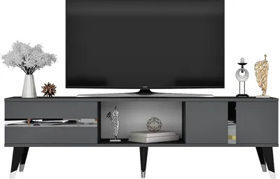 A TV stand with a television on top and decorative items on the stand.