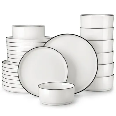 A collection of white ceramic plates and bowls with thin black rims, neatly stacked and arranged.