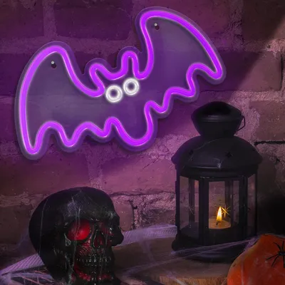 A Halloween-themed display with a neon bat light, a skull, and a lantern.
