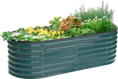 A green metal raised garden bed filled with various plants.