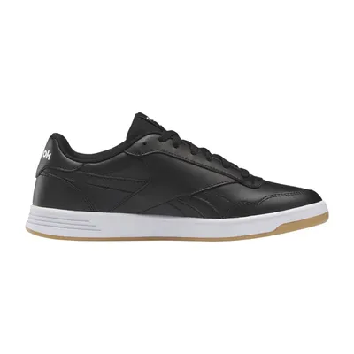 A black Reebok sneaker with a white sole and a gum-colored outsole is shown against a white background.