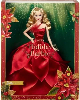 A Barbie doll in a red dress, presented in its packaging with holiday-themed decorations.