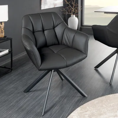 A black leather chair with a metal base in a modern room setting.