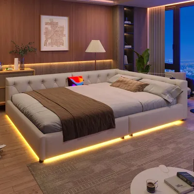 A modern bedroom with a large bed featuring integrated LED lighting, a tufted headboard, and a city view from the window.