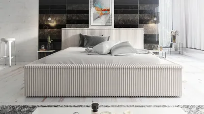 A modern bedroom with a bed, bedside tables, and artwork on the wall.