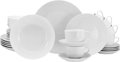 A collection of white porcelain dinnerware, including plates, bowls, cups, and saucers, arranged in a studio setting.