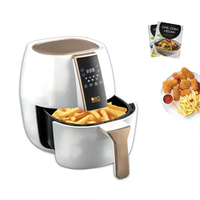 A white and gold air fryer with a digital display, filled with french fries, is shown next to a plate of chicken nuggets and fries, and two recipe books.