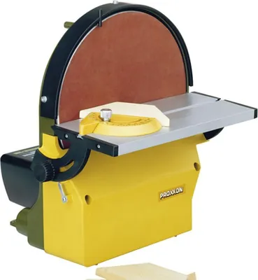 A yellow and black disc sander with a brown sanding disc is shown against a white background.