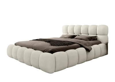 A beige upholstered bed with a metal frame, shown from a side angle against a white background.