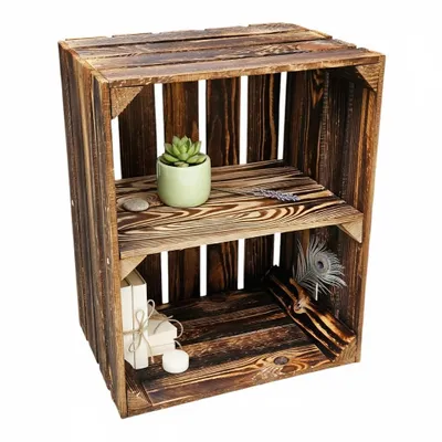 A wooden crate with two shelves, decorated with a plant, a stone, dried lavender, a feather, and two small gift boxes with a candle.
