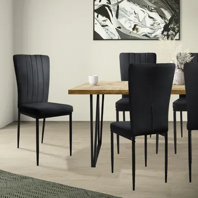 A dining room setting with a wooden table and black chairs.