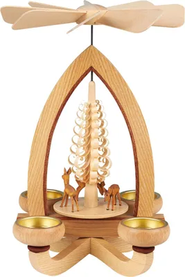 Zu sehen ist eine hölzerne Teelichtpyramide mit einem filigranen Baum in der Mitte umgeben von kleinen Rehfiguren und vier Teelichthaltern die durch die Wärme die Flügel oben in Bewegung setzen