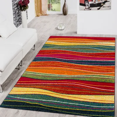 A colorful striped rug is placed on a light gray floor next to a white sofa in a living room.