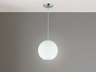A white globe pendant light hanging from a ceiling against a gray wall.