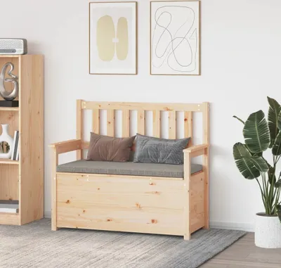 A wooden storage bench with cushions and pillows sits in a room next to a bookshelf and a plant.