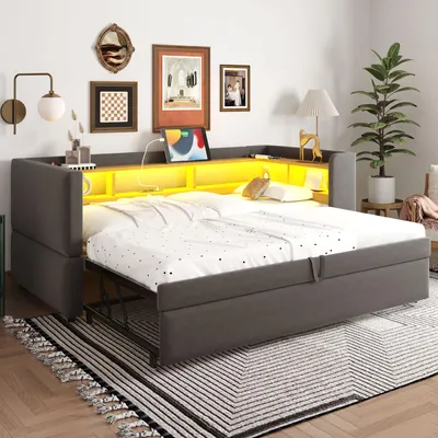 A modern living room with a gray sofa bed that converts into a larger bed, featuring built-in yellow LED lighting and storage compartments.