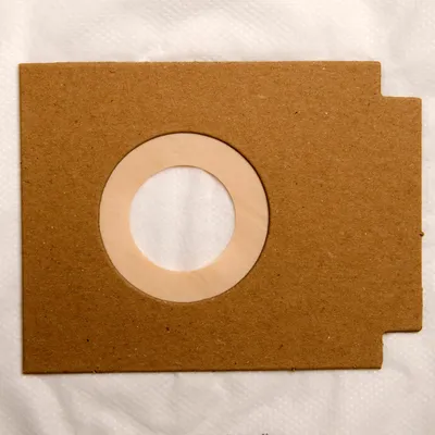 A close-up of a vacuum cleaner bag's paper collar and opening.