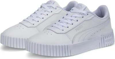 A pair of white Puma Carina 2.0 Jr sneakers are shown from a slightly elevated front-left angle against a white background.