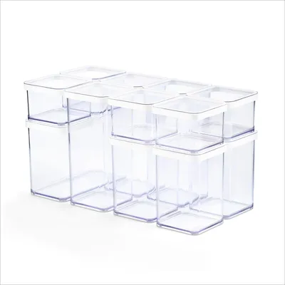 A set of clear plastic food storage containers with white lids, arranged in a grid on a white background.