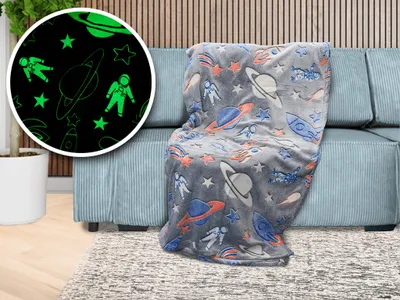 A glow-in-the-dark space-themed blanket draped over a sofa.