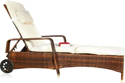 A wicker-style chaise lounge with a cream-colored cushion and a small red pillow.